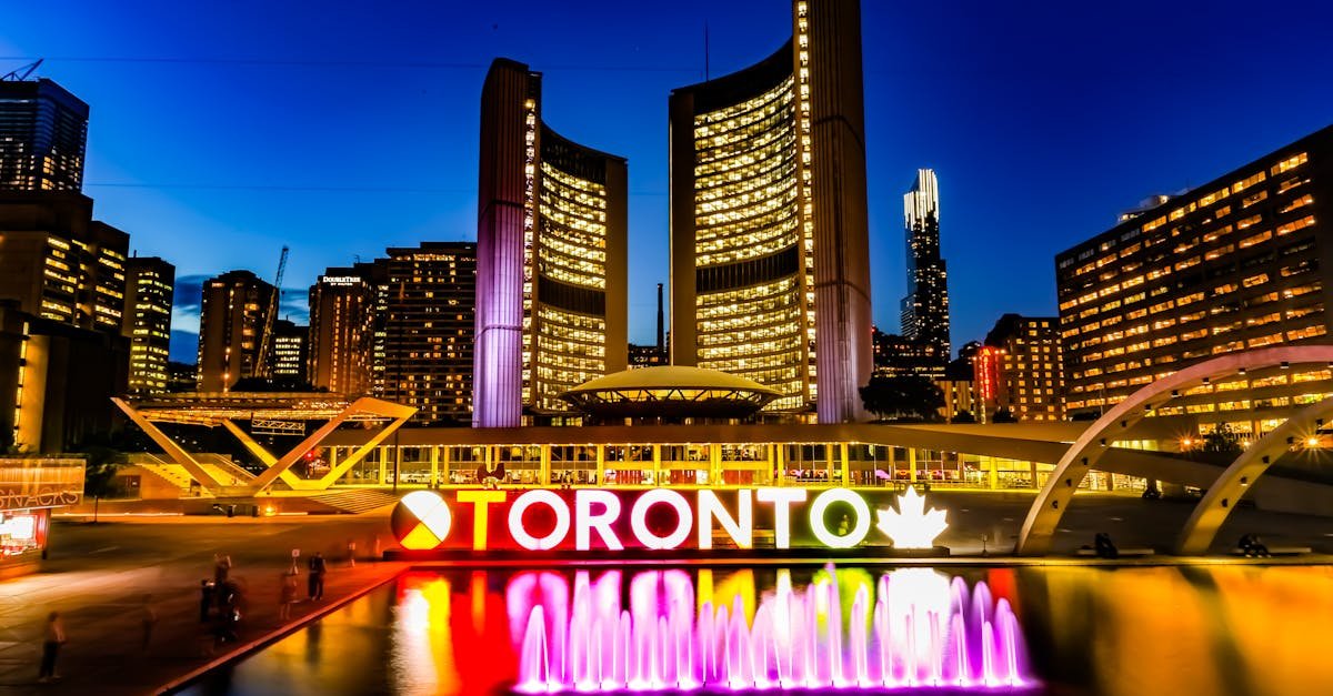 Dazzling Toronto skyline with iconic sign and fountain at dusk.